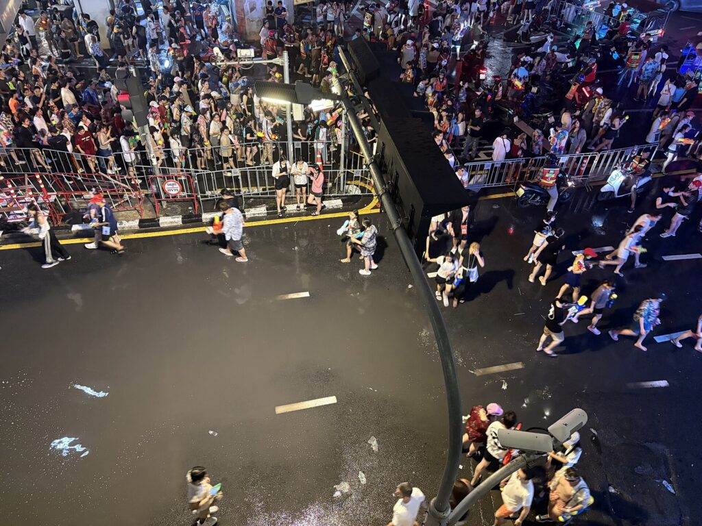 Crowds throwing water on a closed city street during Songkran in Bangkok