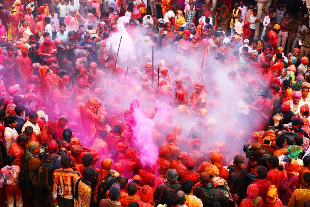 Crowds throwing coloured powder during Holi on a street in north India