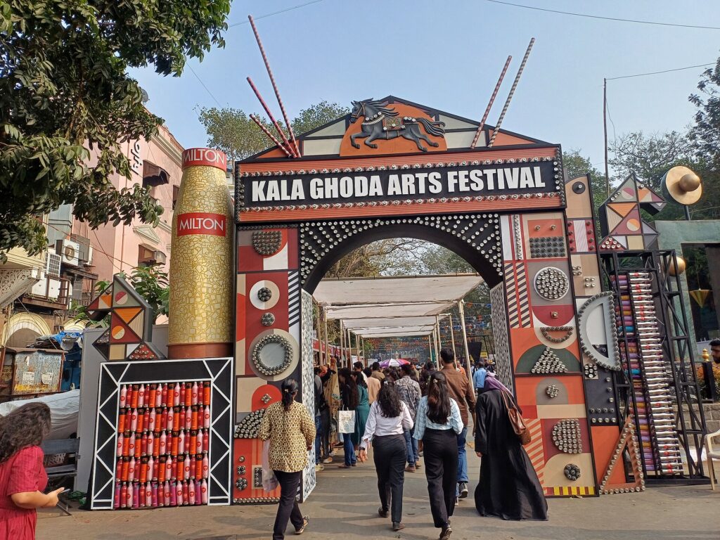 Festival-goers queueing at a festival entrance gate with wristbands ready