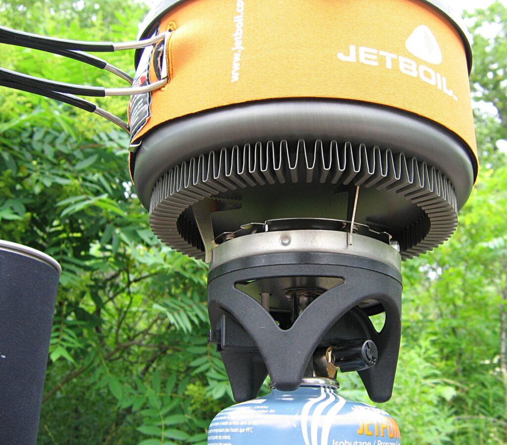 Camp stove, kettle and open esky beside a tent at a festival campsite