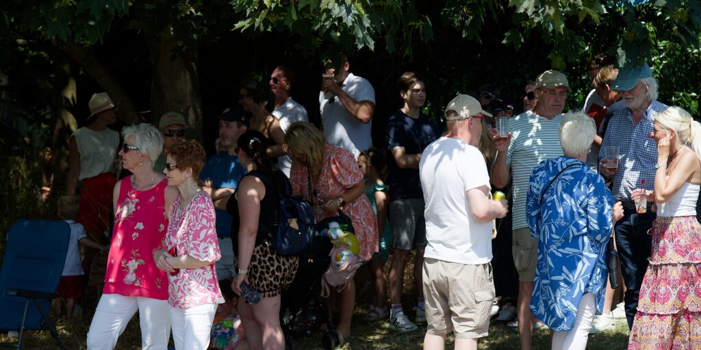 Festivalgoer drinking water in the shade of a tent on a hot day