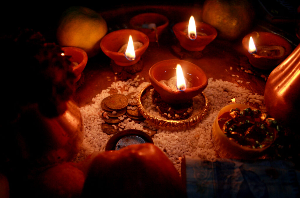 Rows of lit clay diyas along a stone doorway at night during Diwali
